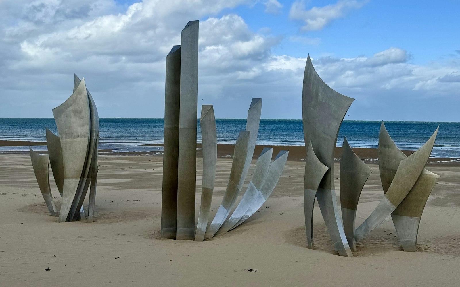 The Les Braves steel sculpture standing on the sand of Omaha Beach